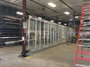 photo of metal gate in fabrication area. commercial gates Cedar Rapids, Iowa fence company fencing contractors double single cantilever roller slide vertical lift vertical pivot oramental picket decorative chain link security commercial industrial correctional prison manufacturing hinges hardware swing drive way estate perimeter 